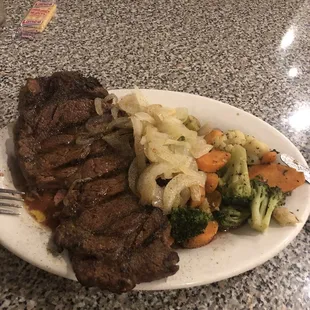 Ribeye cooked perfectly to medium rare. Butter grilled onions and grilled mixed vegetables.