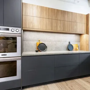 Large U-shaped kitchen features two-tone cabinetry, automated upper cabinet doors, integrated storage features and an appliance garage.