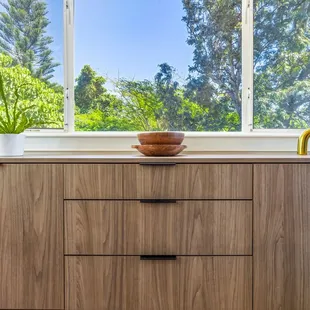 Custom buffet for storing dishware, designed to coordinate with the adjacent kitchen in a complimentary finish.