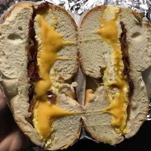 a hand holding a half eaten sandwich