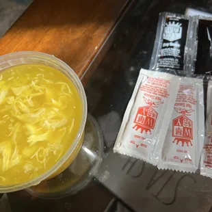 a bowl of soup and two packets of candy