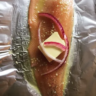 a piece of salmon with cheese and onions
