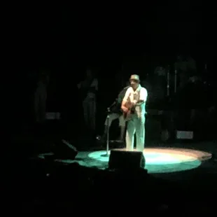 a man playing a guitar on stage