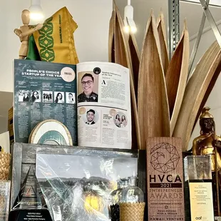 A shelf of accolades for Pono Potions and it's founder + a collection of local craft.