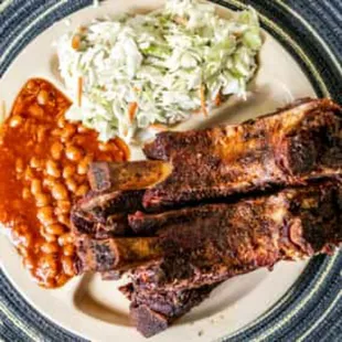 Beef rib platter with sauce on the side with slaw and beans