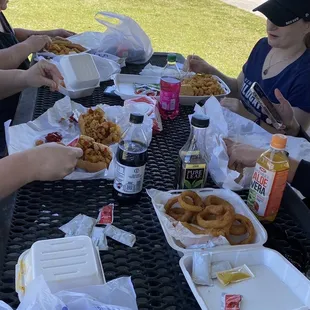 a group of people eating at a picnic table