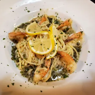 a plate of pasta with shrimp and lemon