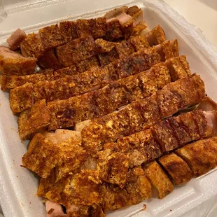 a tray of ribs in a styrofoam container
