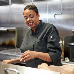a woman preparing food in a commercial kitchen