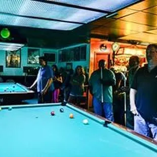 a group of people playing pool
