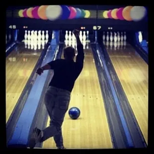 a man throwing a bowling ball