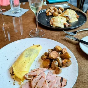 Far: Eggs Benedict; near: Mushroom and Swiss Omelette with country ham. Both are Brunch items.