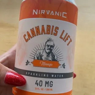 a person holding a can of cannabis lit