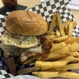 Burger with bacon and an egg with fries