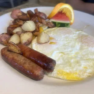 American breakfast with 3 eggs over easy, sausage links, fruit