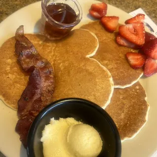 Kids pancakes with bacon and side of strawberries