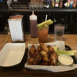 a tray of chicken wings and a drink