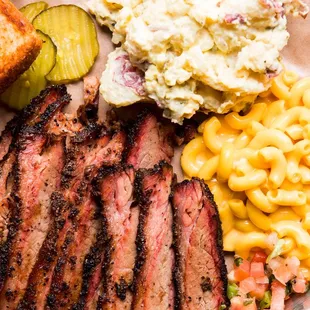 ows a plate of meat, macaroni, and cheese