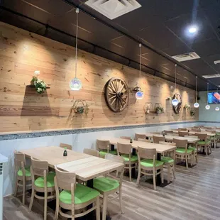 a restaurant with wooden tables and green chairs