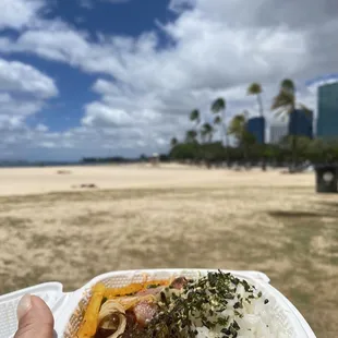 a hand holding a container of food