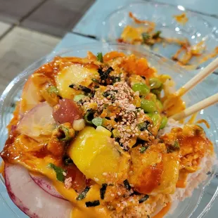 a bowl of food with chopsticks