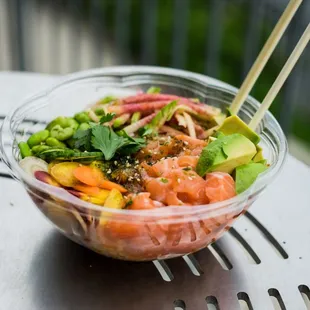 a poke bowl with chopsticks in it