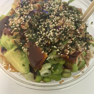 a close up of a bowl of food with chopsticks