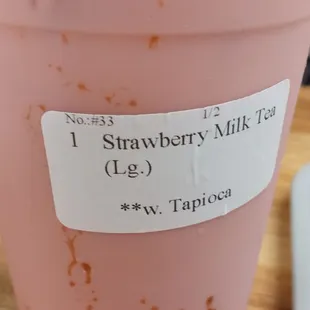a strawberry milkshake in a plastic cup