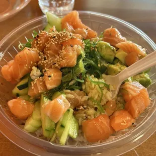 Salmon Poke Bowl with sushi rice, cucumbers, sesame seeds and poke sauce.