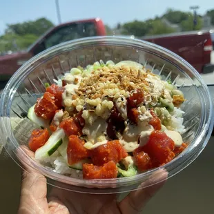 a hand holding a bowl of food