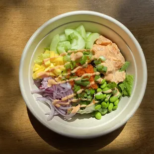 Honolulu Special Poké Bowl. Sushi rice, spring mix, spicy salmon, cucumber, edamame, red onion, mango, masago, green onion, Sriracha aioli.