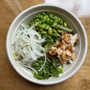 Spicy Ginger Chicken Poké Bowl. Sushi rice, spring mix, chicken, sweet onion, edamame, cilantro, sesame, spicy ginger sauce.
