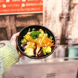 a person holding a bowl of food