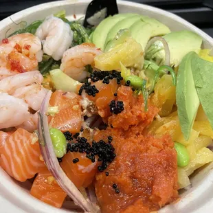 a bowl of sushi with shrimp and avocado