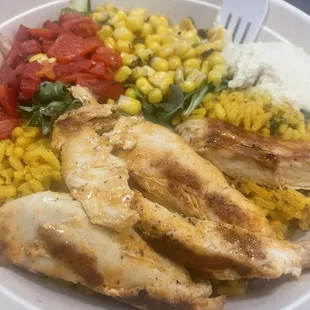 a plate of chicken, corn and tomatoes