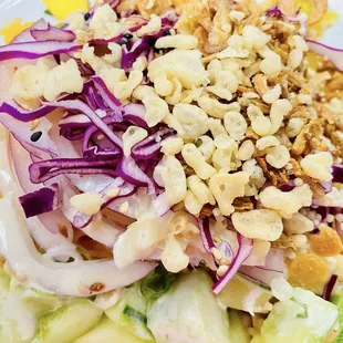Kani salad with zoodles and greens filled with veggies, pineapple and mango