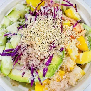Yummy kani bowl with spring mix, rice, cucumber, avo, red &amp; green onion, mango with crunchies