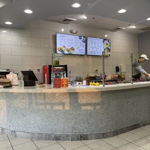 a man standing at a counter in a restaurant