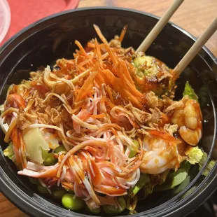 a bowl of food with chopsticks