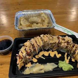 a plate of sushi and a container of sauce