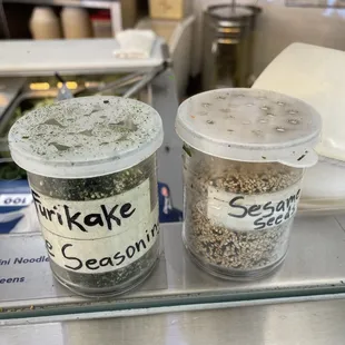 two containers of seasoning on a counter