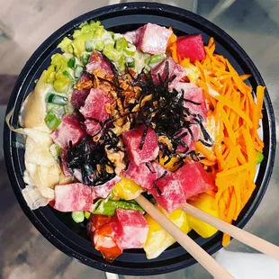 a bowl of food with chopsticks