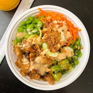 a bowl of food and a glass of orange juice