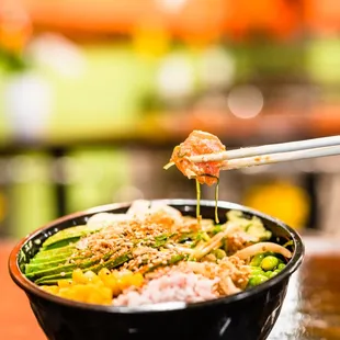 a bowl of food with chopsticks