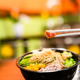 a bowl of food with chopsticks
