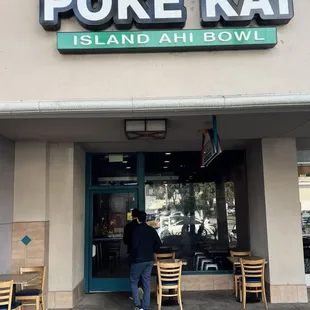 a man standing outside of a restaurant