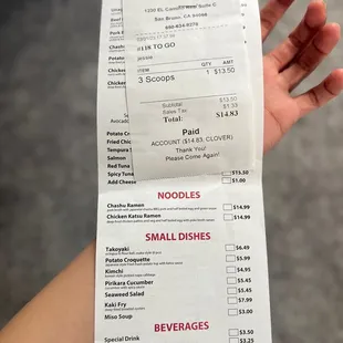 a hand holding a receipt for a small dish