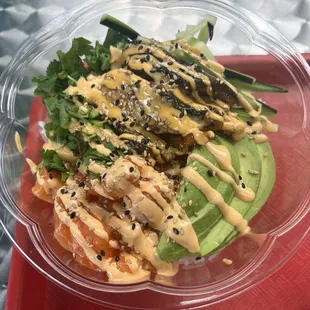 Poke bowl: spicy salmon, eel, cilantro, cucumber and avocado topped with spicy mayo and sesame seed.
