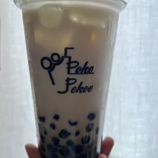 a hand holding a cup of bubble tea