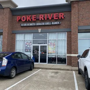 two cars parked in front of a poke river restaurant